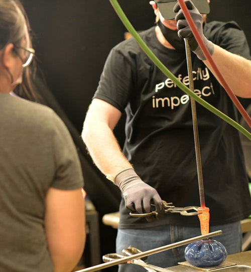 a glassblower and customer created a beautiful hand-blown glass pumpkin together in a glassybaby hot shop.