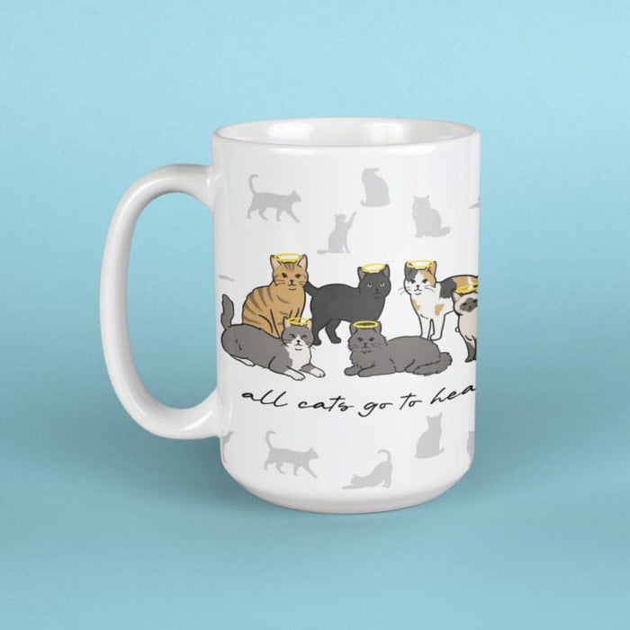 White mug with cat illustrations and text on a light blue background