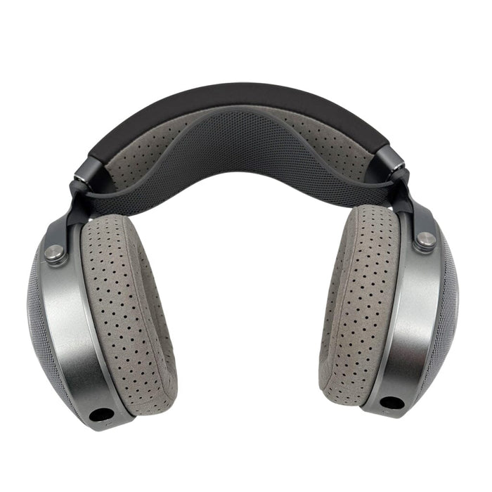 A pair of over-ear headphones featuring gray perforated ear cushions and a black, padded Capra Audio Comfort Strap for Focal Headphones (Large) by Capra Audio, shown front-facing on a white background.