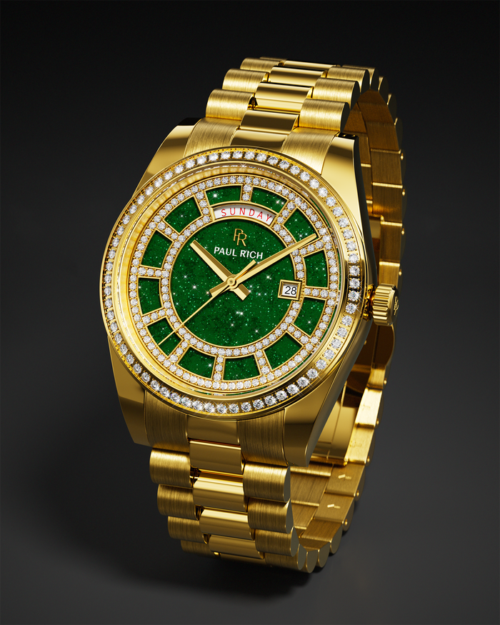Gold watch with a green aventurine dial, full day–date display, pavé diamond bezel, and a gold three-link bracelet shown against a dark background.