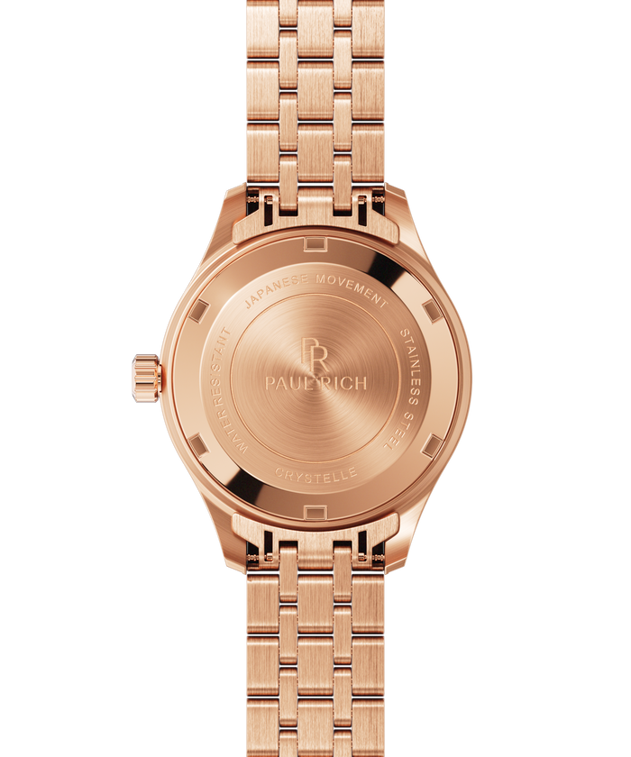 Back view of a rose gold Paul Rich watch with engraved text reading “Japanese Movement,” “Stainless Steel,” “Water Resistant,” and “Crystelle.”