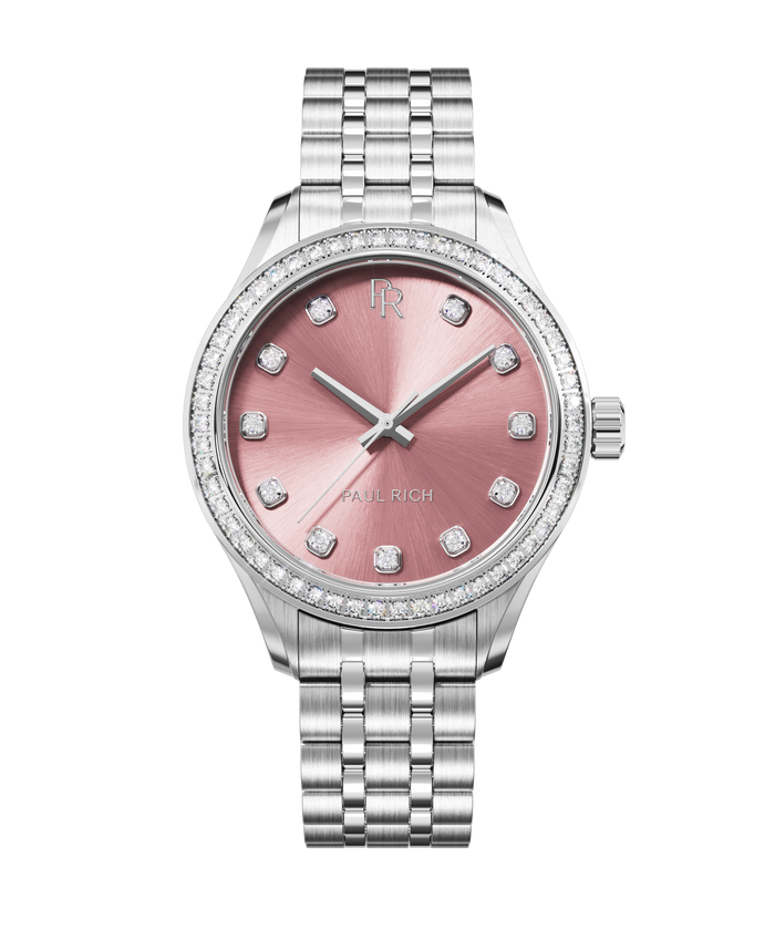 Front view of a silver-tone Paul Rich watch with a pink sunray dial, diamond hour markers, gem-set bezel, and silver jubilee bracelet.