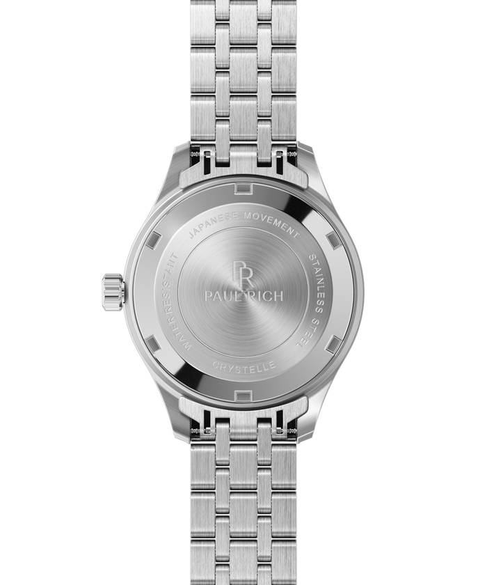 Back view of a silver-tone Paul Rich watch showing engraved text: “Paul Rich,” “Japanese Movement,” “Stainless Steel,” “Water Resistant,” and “Crystelle.”