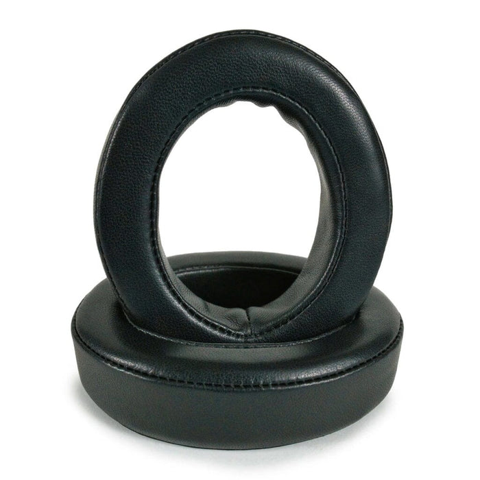 Two black, round Dekoni Audio Replacement Earpads for Focal Bathys, Bathys MG, Hadenys, Azurys & Lensys are shown—one standing upright inside the other—ideal for upgrading your headphones. Isolated on a white background.