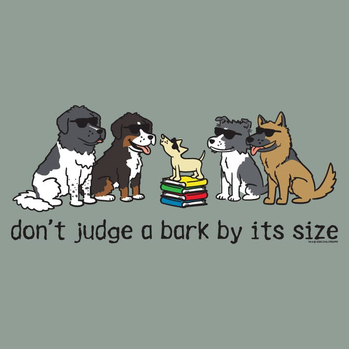 A graphic design featuring five cartoon dogs wearing sunglasses sitting on and around a stack of colorful books, with the text 'don't judge a bark by its size' below. The entire design is centered on a solid muted sage green background.