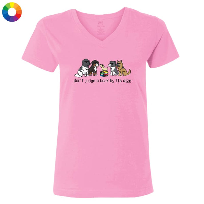 A pink women's V-neck t-shirt featuring a cartoon graphic of dogs and cats with the text 'don't judge a bark by its size' printed on the chest.