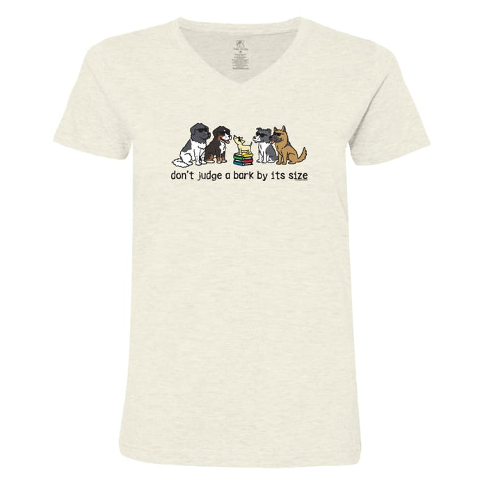 An off-white heathered V-neck t-shirt featuring a cartoon graphic of several dogs sitting together with the text 'don't judge a bark by its size' printed below them.