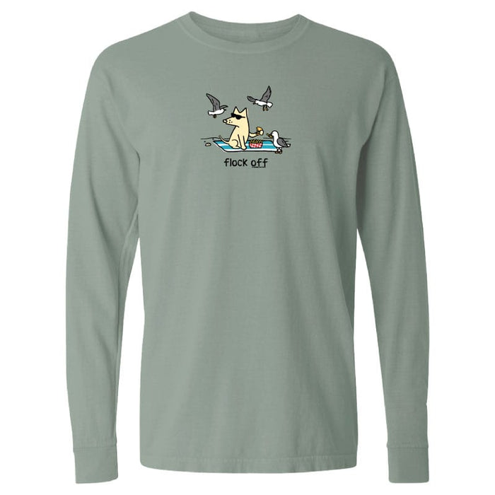 A sage green long-sleeve t-shirt with a graphic of a dog sitting on a board with seagulls flying above and the text 'flock off' printed below.