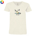 An off-white heather V-neck t-shirt featuring a cartoon graphic of a dog in a boat with seagulls flying overhead and the text 'flock off'. A color wheel icon is visible in the top-left corner.
