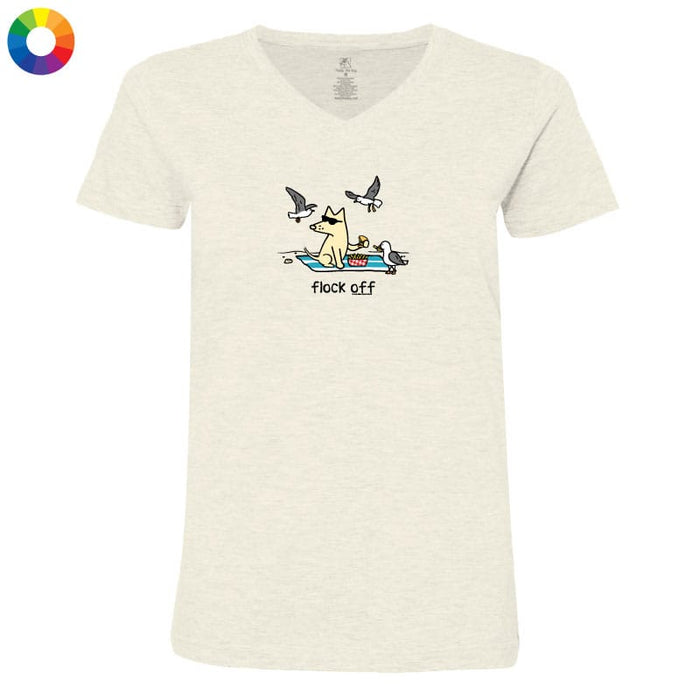 An off-white heather V-neck t-shirt featuring a cartoon graphic of a dog in a boat with seagulls flying overhead and the text 'flock off'. A color wheel icon is visible in the top-left corner.