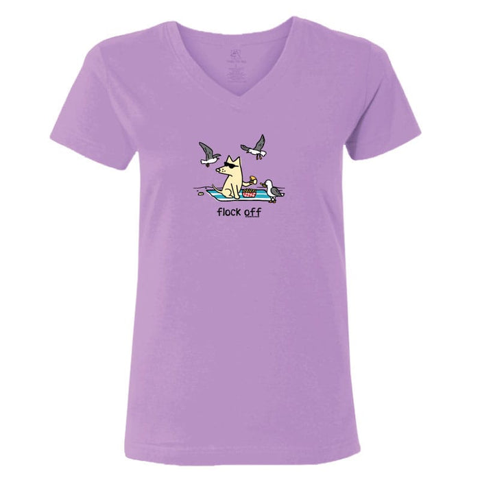 A light purple short-sleeve V-neck t-shirt with a cartoon graphic of a dog sitting on a towel in a boat with seagulls flying around it and the text 'flock off' printed below.