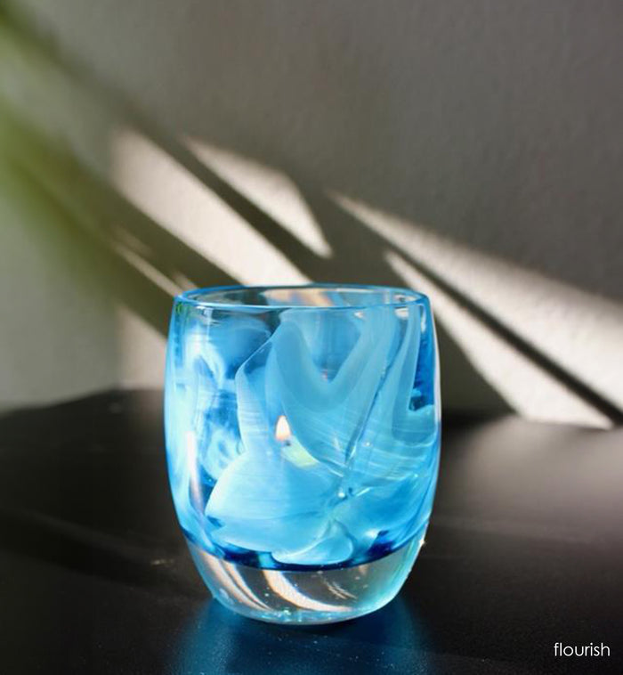 'flourish' is adorned with blue murrini flowers. This hand-crafted glass votive candle holder