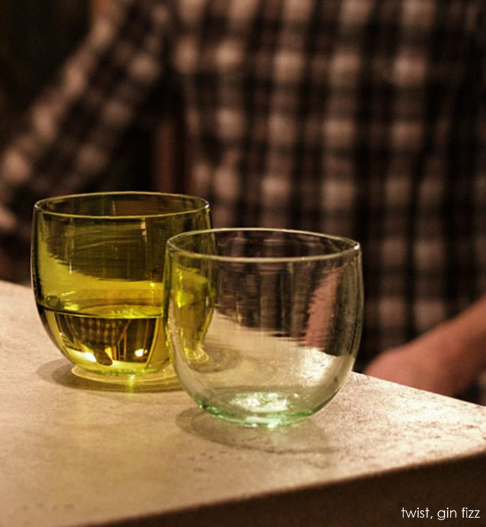 gin fizz drinker, transparent light green hand-blown drinking glass. Paired with twist.