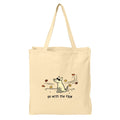 A natural beige canvas tote bag with two shoulder straps, featuring a minimalist black line art illustration of a dog surrounded by autumn leaves and the text 'go with the flow' printed on the front.