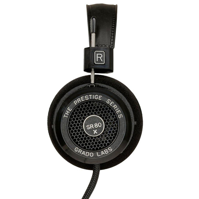 Close-up of the Grado SR80x Headphones by Grado, showing the right ear cup with foam padding, mesh grille, and braided cable—equipped with X Series Driver for an enhanced soundstage.