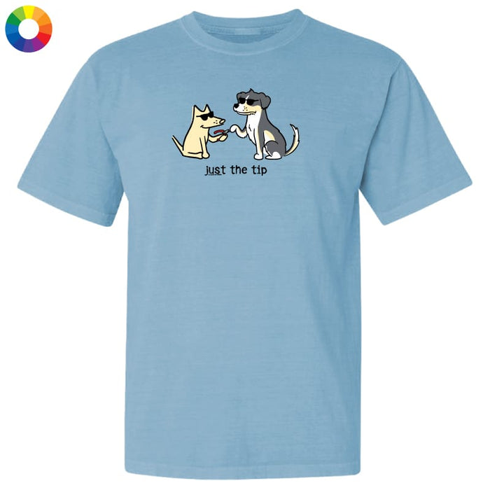 A light blue short-sleeve crewneck t-shirt featuring a cartoon graphic of two dogs shaking hands with the text 'just the tip' underneath. A small multicolor color wheel icon is visible in the top-left corner.