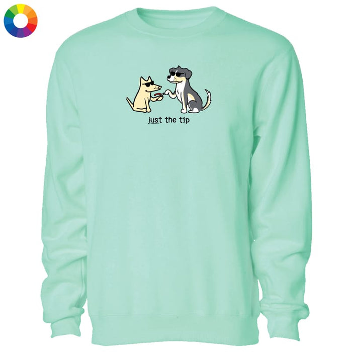 A mint green crewneck sweatshirt featuring a cartoon graphic of a yellow dog and a black-and-white cat shaking paws with the text 'Just the tip' underneath. A small multicolor color wheel icon is visible in the top-left corner.