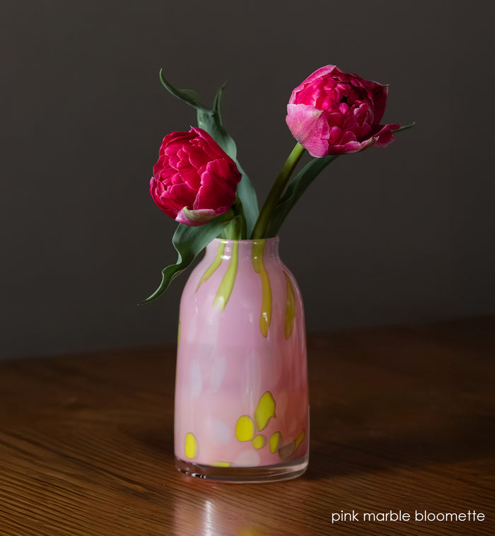 pink marble bloomette vase with bring pink flowers in it on wood surface
