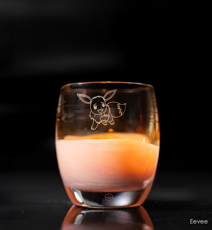 Glass candle holder with Eevee engraving on a dark background