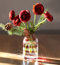 clear handblown glass bloomette with red twisted around it. with red flowers in vase.