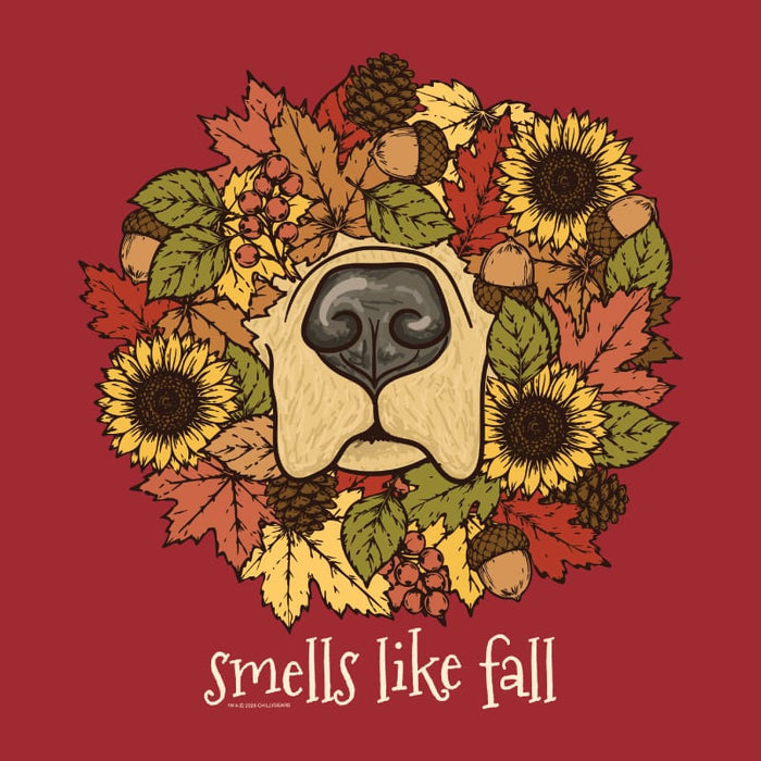 A graphic design featuring a circular wreath of autumn leaves, sunflowers, acorns, and pinecones surrounding a stylized dog nose, with the text 'smells like fall' below on a solid dark red background.