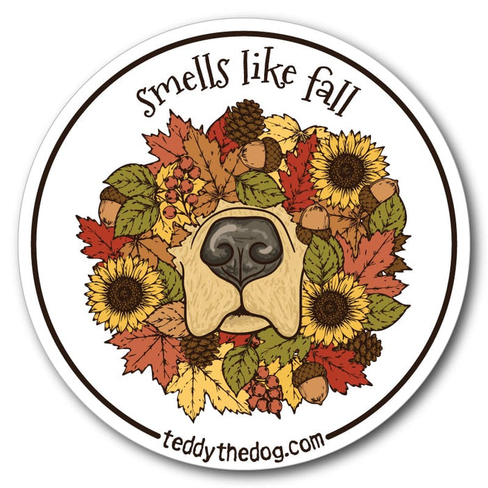 A round sticker or decal with a white border and the text 'smells like fall' at the top and 'teddythedog.com' at the bottom.