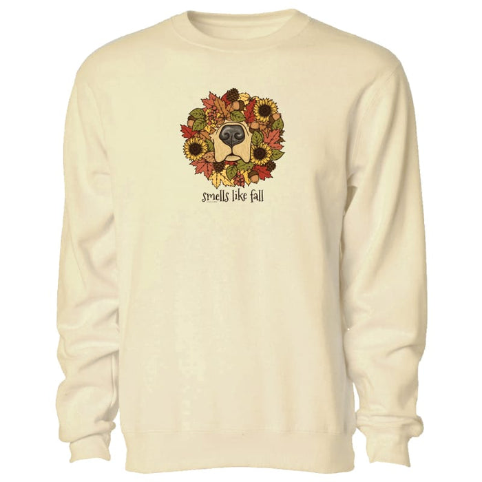 A cream-colored crewneck sweatshirt featuring a graphic of a dog's face surrounded by autumn leaves and sunflowers, with the text 'smells like fall' printed below.