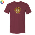 A maroon short-sleeve crewneck t-shirt featuring a graphic of a dog's face surrounded by autumn leaves and sunflowers, with the text 'smells like fall' printed below. A small multicolor color wheel icon is visible in the top-left corner.