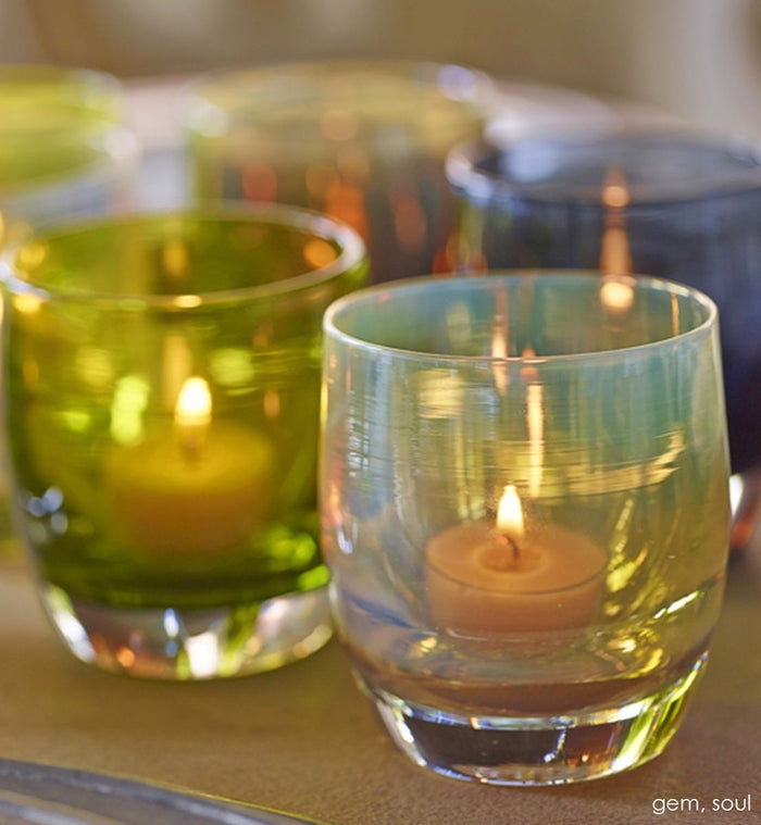 soul iridescent golden white hand-blown glass votive candle holder on a table with gem.