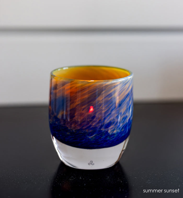 'summer sunset' glassybaby | red, yellow, and blue hand-blown glass candle holder on black table