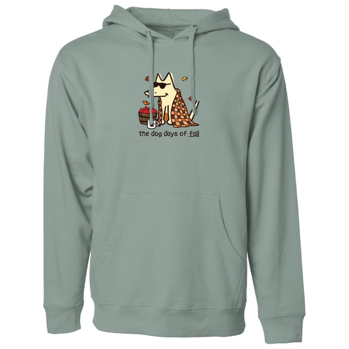 A sage green pullover hoodie with a front kangaroo pocket and drawstring hood, featuring a cartoon graphic of a dog wearing sunglasses and a checkered blanket next to a hotdog, with the text 'the dog days of fall' printed below.