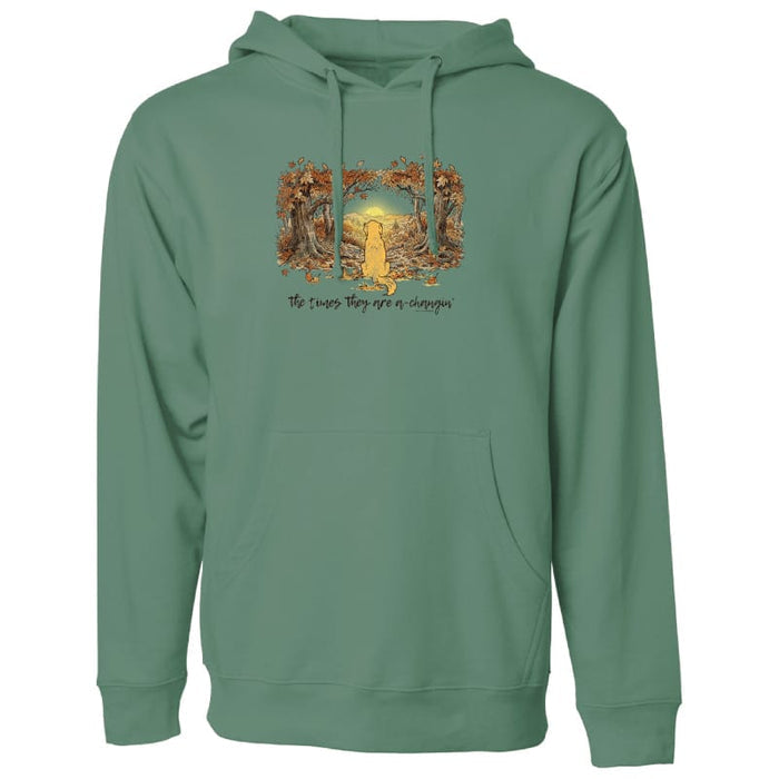 A sage green pullover hoodie with a front kangaroo pocket and drawstring hood, featuring a graphic print of a golden retriever framed by autumn trees with the text 'The times they are a-changin'' on the chest.