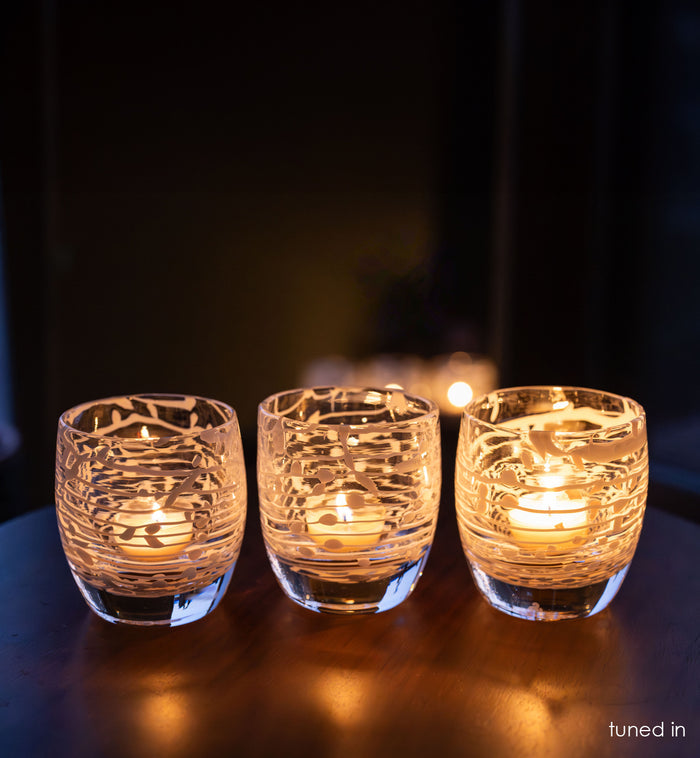 3 tuned in, clear white white strings wrapped around hand-blown glass candle holders