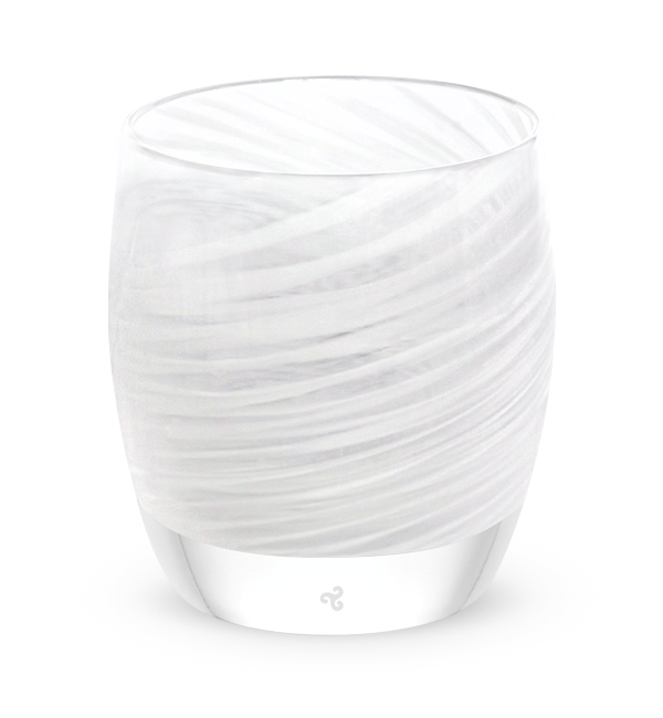 Glass candle holder with wavy design on a dark surface and gray background