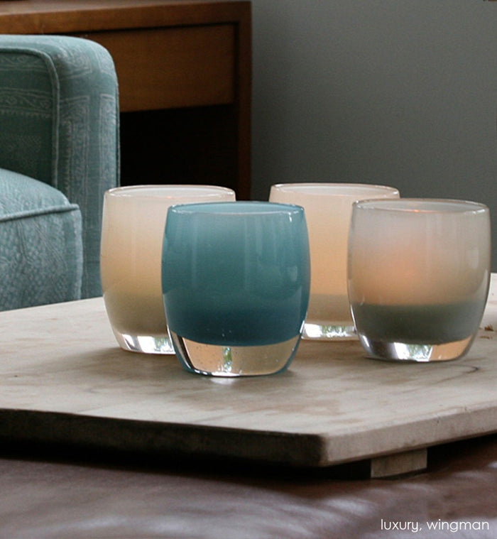 wingman, harbor gray, hand-blown glass votive candle holders with luxury on a wood tray on a living room leather ottoman.